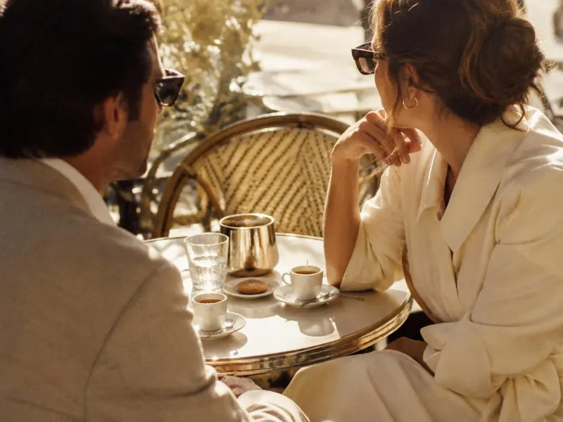 Deux personnes en conversation à une terrasse de café