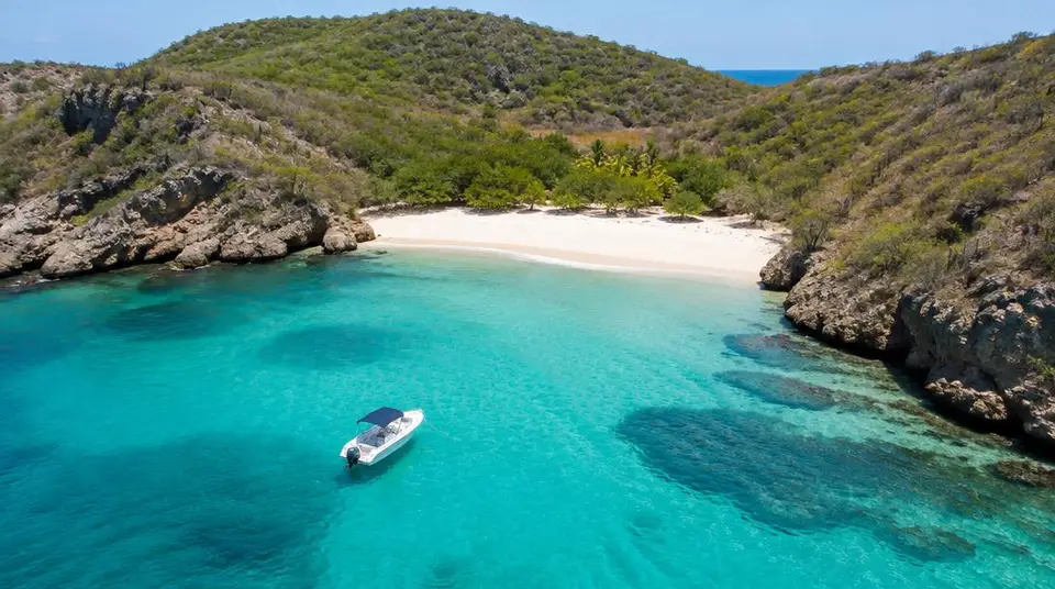 Bateau à moteur dans une anse turquoise de Saint-Barth